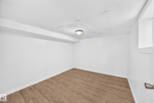 Wood-finish flooring, white walls, and a drop ceiling with recessed lighting - Edmonton, AB 
