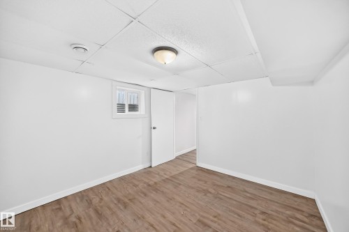 Recessed window with white trim, wood-finish flooring, drop ceiling with flush-mount lighting - Edmonton, AB 