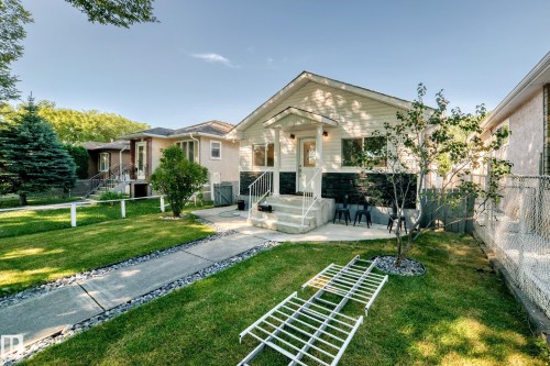 Manicured front lawn with a concrete walkway and decorative stone accents - Edmonton, AB 