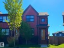 Red siding exterior with dark trim windows, front entry with covered porch, and brown wood fencing - 5169 Chappelle Rd Southwest, Edmonton, AB 