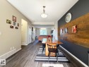 Wood-finish flooring, accent wall with wood paneling, recessed lighting, and a contemporary ceiling fixture - 5169 Chappelle Rd Southwest, Edmonton, AB 