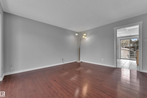 Wood-finish flooring, light gray wall paint, and white trim molding - 3227 145 Avenue Nw, Edmonton, AB 