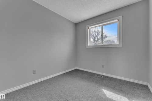 Neutral gray wall paint, gray carpet flooring, white trim, and a window with white casing - 3227 145 Avenue Nw, Edmonton, AB 
