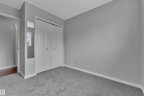 Gray wall paint, carpeting, white trim, and a bi-fold closet - 3227 145 Avenue Nw, Edmonton, AB 