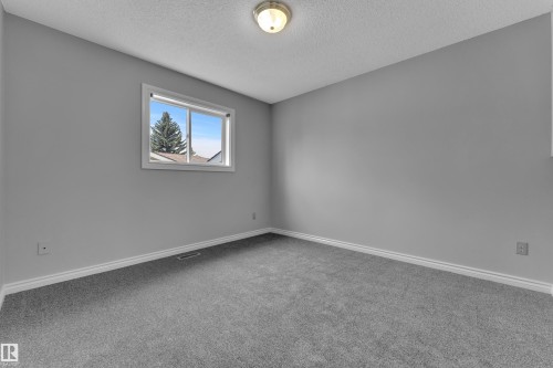 Neutral wall color, wall-to-wall carpeting, single window, flush mount ceiling light fixture, and white trim - 3227 145 Avenue Nw, Edmonton, AB 