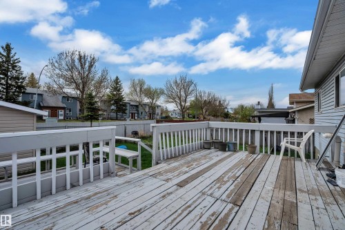 Expansive composite deck featuring horizontal wood-finish decking, white composite railings with balusters, and multiple levels—ideal for entertaining and outdoor living - 3227 145 Avenue Nw, Edmonton, AB 