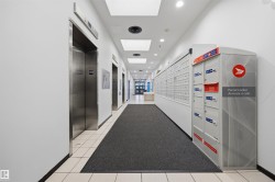 Lobby with multiple stainless steel elevators, recessed lighting, and a mailroom area featuring individual mailboxes and parcel lockers - 