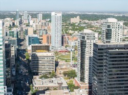 Urban landscape featuring multiple high-rise buildings and extensive tree-lined streets - 