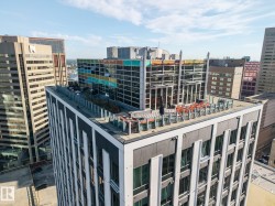 Rooftop terrace featuring glass railings and multiple seating areas - 