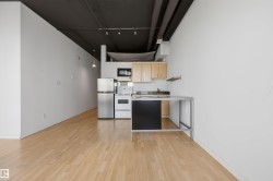 Open-concept space featuring light-toned wood flooring and white walls - 