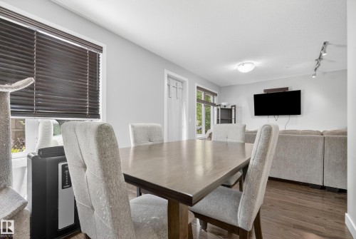Wood-finish flooring throughout, light gray wall color, and track lighting - #107 1031 173 St Sw, Edmonton, AB 