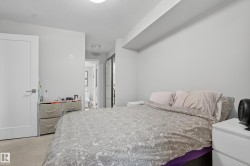Neutral wall paint, light-toned carpet flooring, and a modern white door with a metal handle - 
