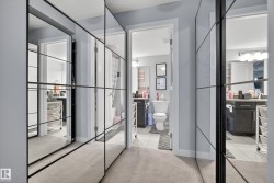 Mirrored closet doors with black framing, light gray wall paint, and carpeted flooring - 