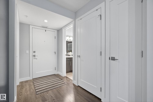 Wood-finish flooring, recessed ceiling lighting, and solid core doors with brushed nickel hardware - #107 1031 173 St Sw, Edmonton, AB 
