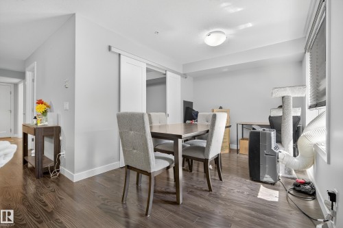 Wood-finish flooring, white walls, and a barn door entry - #107 1031 173 St Sw, Edmonton, AB 