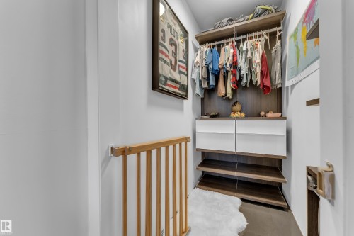 Custom closet system with wood-finish shelving, built-in drawers, and hanging rods - 442 Kirkpatrick Crescent Nw, Edmonton, AB 