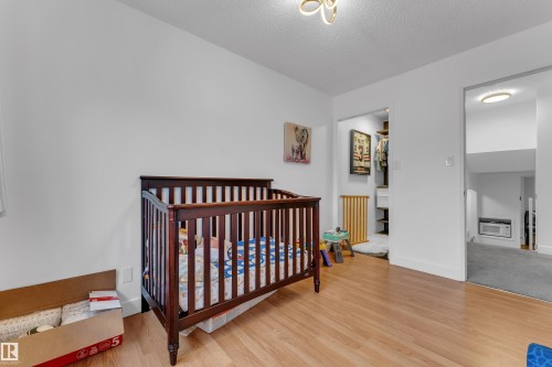 Hardwood-style flooring throughout, white painted walls, and overhead lighting - 442 Kirkpatrick Crescent Nw, Edmonton, AB 