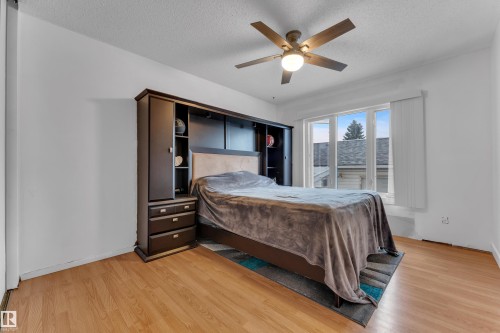 Hardwood-finish flooring, a contemporary ceiling fan, and a built-in dark wood storage unit with shelving - 442 Kirkpatrick Crescent Nw, Edmonton, AB 