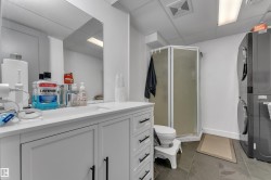White vanity with matte black hardware, integrated sink, and large wall-mounted mirror - 