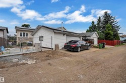 Detached garage with white siding and a sloped roof - 