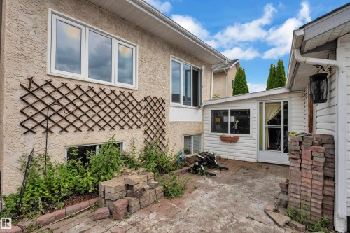 Stucco exterior with white-framed windows - 442 Kirkpatrick Crescent Nw, Edmonton, AB 