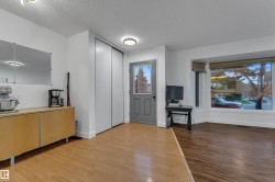 Bay window with exterior scenery, wood-finish flooring, and white walls - 