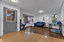 Entryway with light wood-finish flooring, leading into a living area with dark wood-finish flooring - 