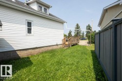 Rear exterior featuring white horizontal siding and a visible foundation - 