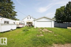 Detached garage featuring a white overhead door and white siding - 