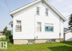 White siding exterior with multiple windows and a pitched roofline - 