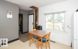 Light-filled interior space featuring a large window, neutral wall paint, and carpeted flooring - 
