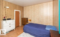 Interior room featuring two distinct panel wall finishes and a brown door with white trim - 
