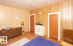 Interior room featuring wood-panel walls and two panel doors with white trim - 