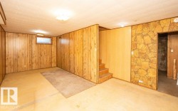 Finished room featuring wood paneling, a textured ceiling, and a rectangular window - 