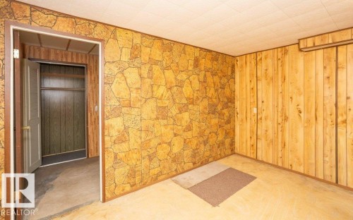 Room featuring paneling with a stone-look pattern and vertical wood paneling - 10940 100A Ave, Westlock, AB - Indoor Photo Showing Other Room