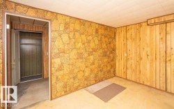 Room featuring paneling with a stone-look pattern and vertical wood paneling - 