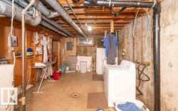 Unfinished basement space with exposed ceiling joists and plumbing - 