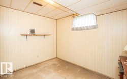 Room featuring light-toned striped wallpaper, drop ceiling with integrated ventilation, and a window with a sheer curtain - 