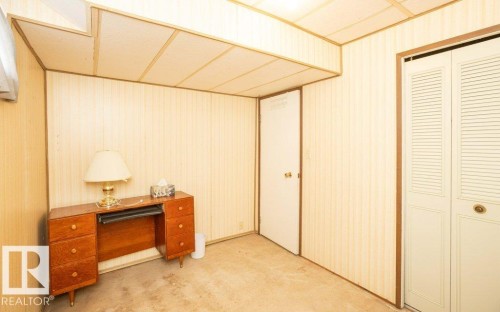 Room featuring vertical paneling, acoustic ceiling tiles, and carpet flooring - 10940 100A Ave, Westlock, AB - Indoor Photo Showing Other Room