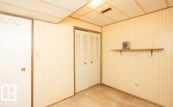 Room featuring light-toned vertical paneled walls, a drop ceiling, and carpeted flooring - 