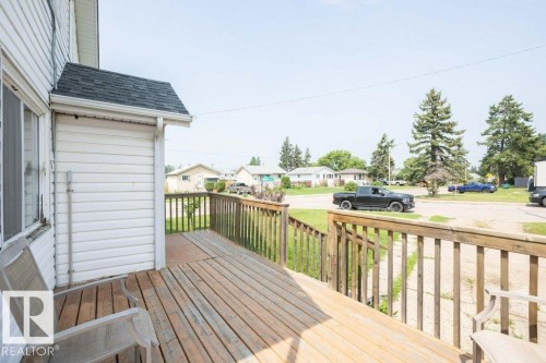 Expansive wooden deck featuring natural wood railings and siding with white vinyl siding - 10940 100A Ave, Westlock, AB - Outdoor With Deck Patio Veranda With Exterior