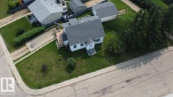 Corner property featuring a white exterior, gray shingle roof, and a rear deck - 