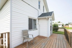 Expansive wood deck with a full railing and white siding exterior - 