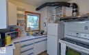 White cabinetry with blue trim, countertop space, kitchen sink, wall-mounted shelving, and window - 10204 123 Avenue Nw, Edmonton, AB 