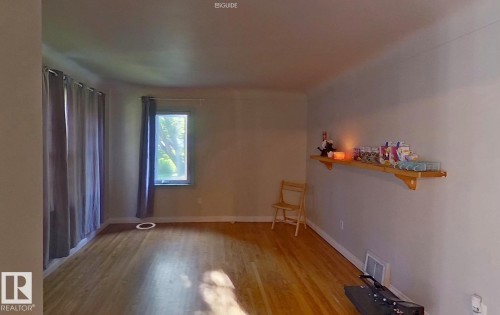 Wood-finish flooring, light-toned walls, and a window with natural light - 10204 123 Avenue Nw, Edmonton, AB 