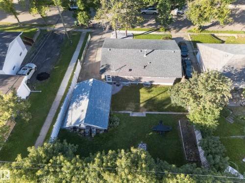 Expansive backyard featuring a manicured lawn, mature trees, and a detached structure - 21 Sheridan Drive, St. Albert, AB 