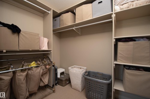 Built-in shelving with multiple storage levels and hanging rods - #5 5120 164 Av Nw, Edmonton, AB 