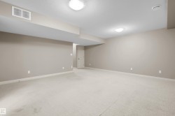 Neutral-toned walls with contrasting white trim, recessed lighting, and light-colored carpet - 