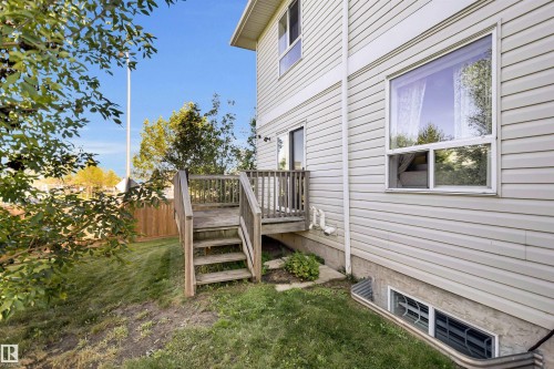 Exterior with light-colored siding, multiple windows, and a wooden deck with railing and stairs - #5 5120 164 Av Nw, Edmonton, AB 