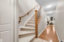Carpeted staircase with wood banister and wrought iron spindles - #5 5120 164 Av Nw, Edmonton, AB 